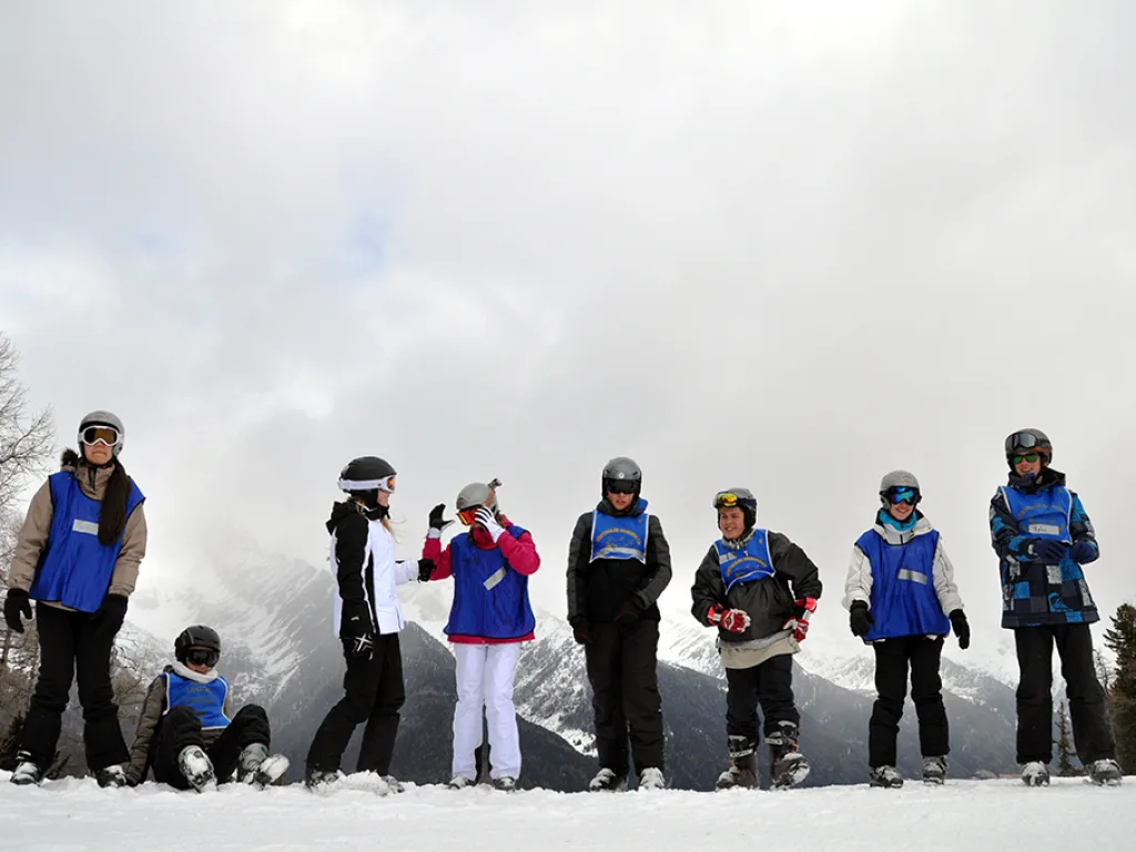 Gruppe posiert nebeneinander auf der Piste.